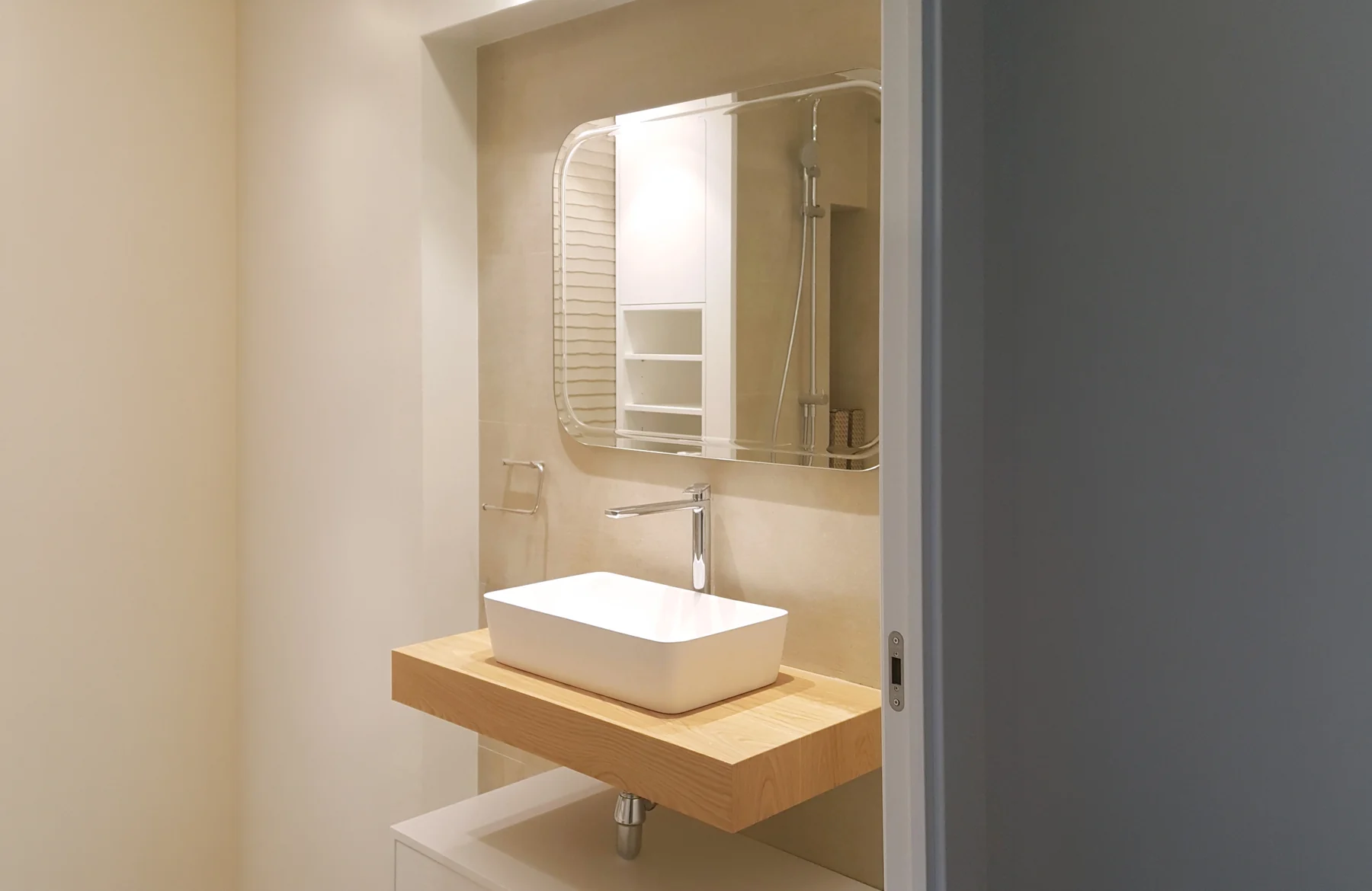 Baño con lavabo sobre encimera de madera en una vivienda reformada en Castelldefels