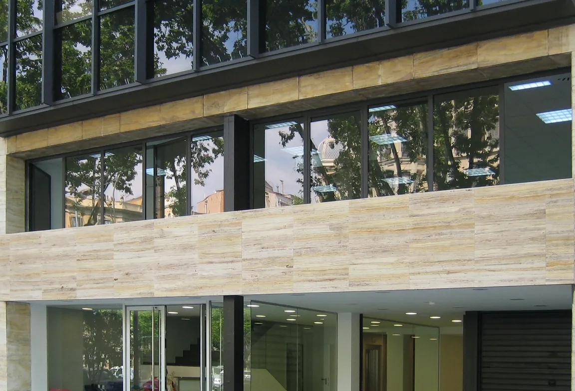 Fachada de planta baja con travertino y cristal en el Passeig de Sant Joan